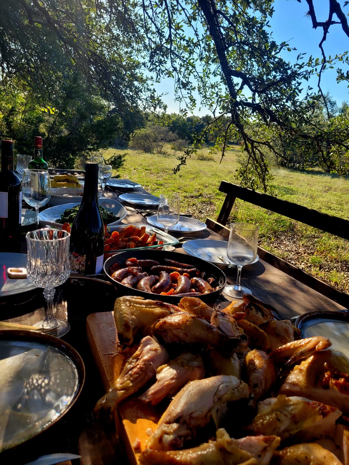 The feast laid out with wine bottles, sausages and carved chicken