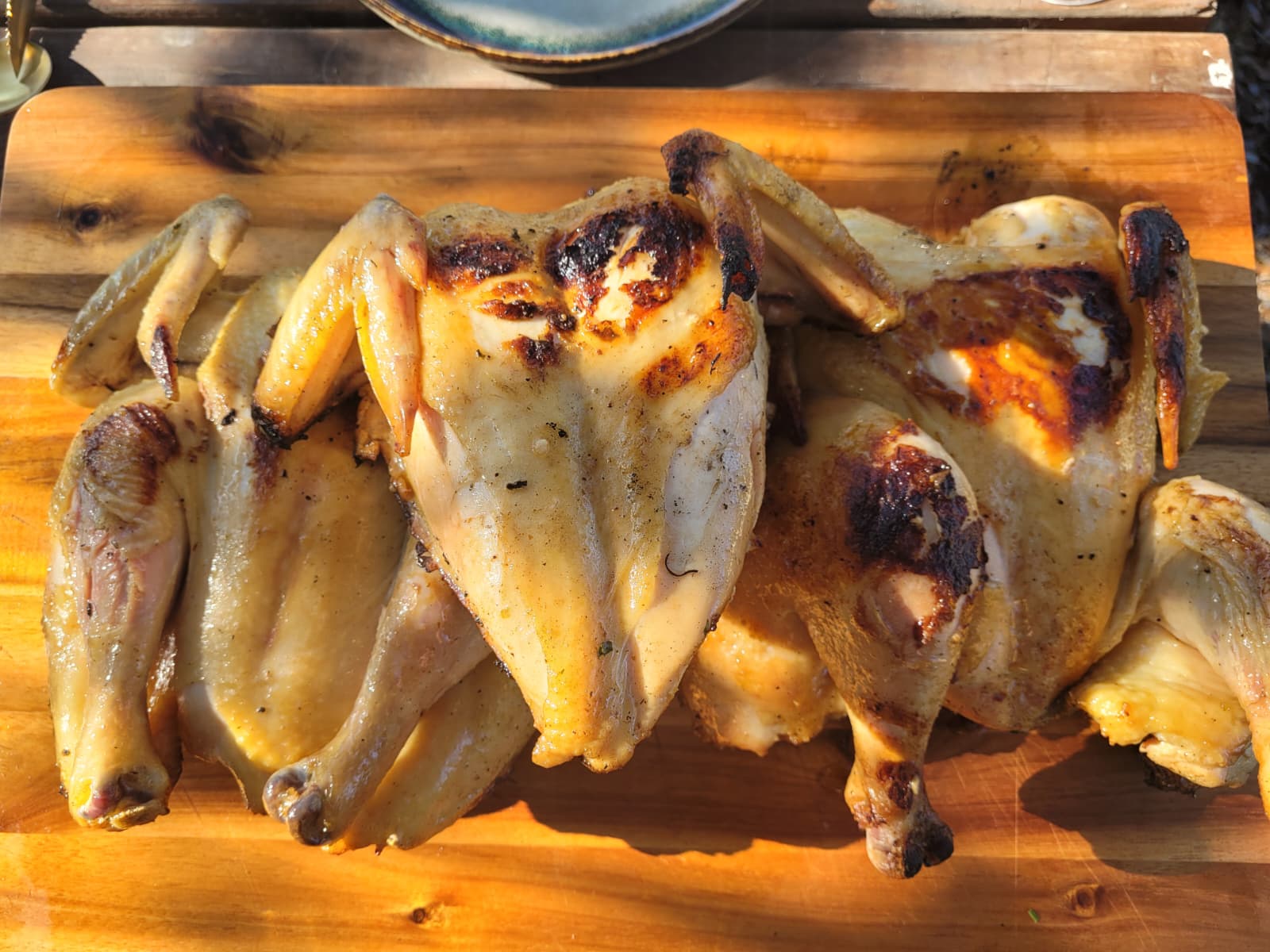 Golden spatchcock chickens on a wooden board