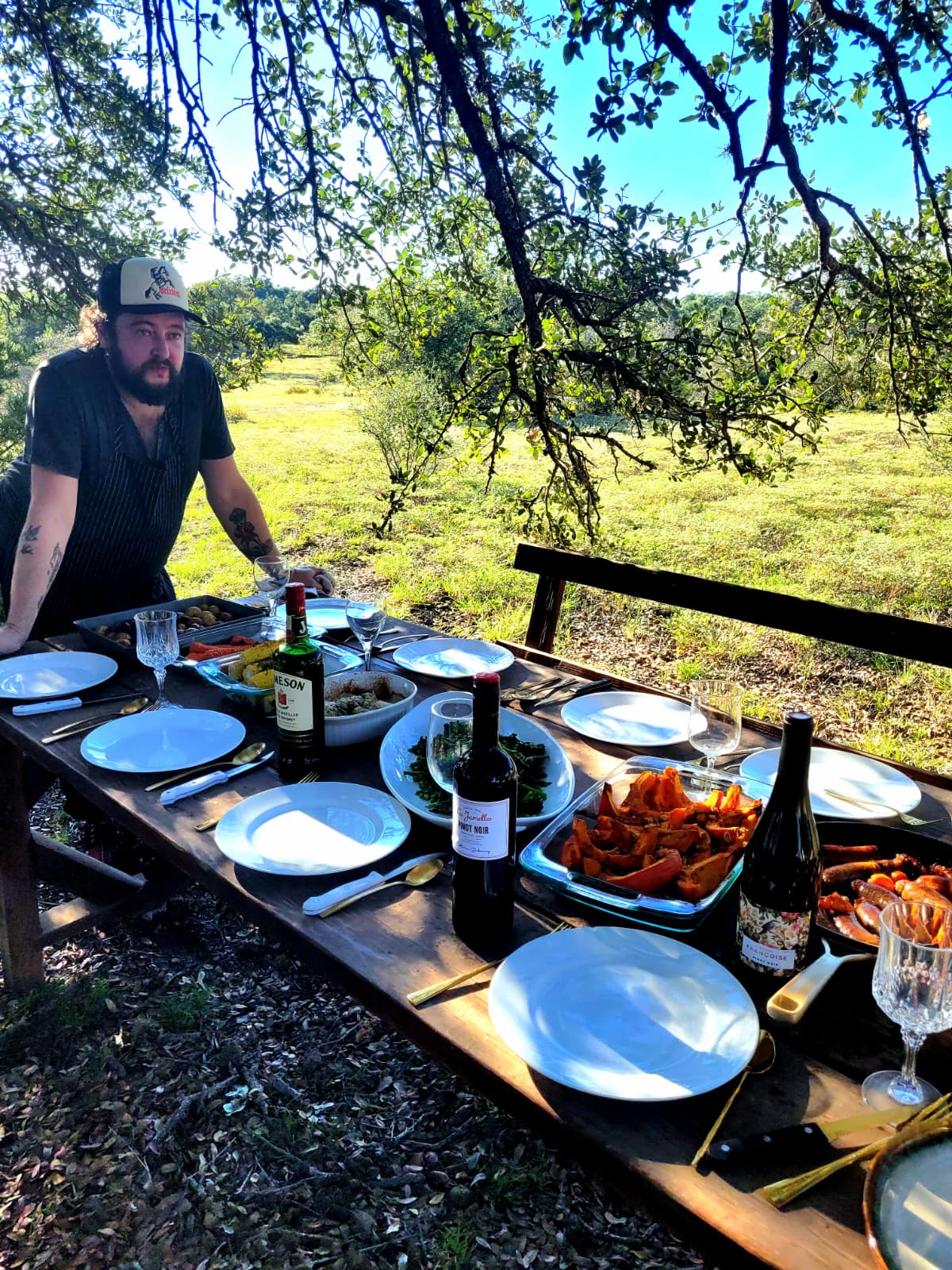 Alfie Milner at a long table of food in the Texas Hill Country